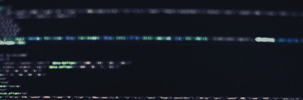 Out-of-focus lines of code on a dark screen